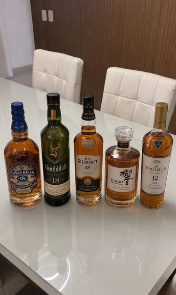 Five bottles from the Pure Whisky collection on a dining table